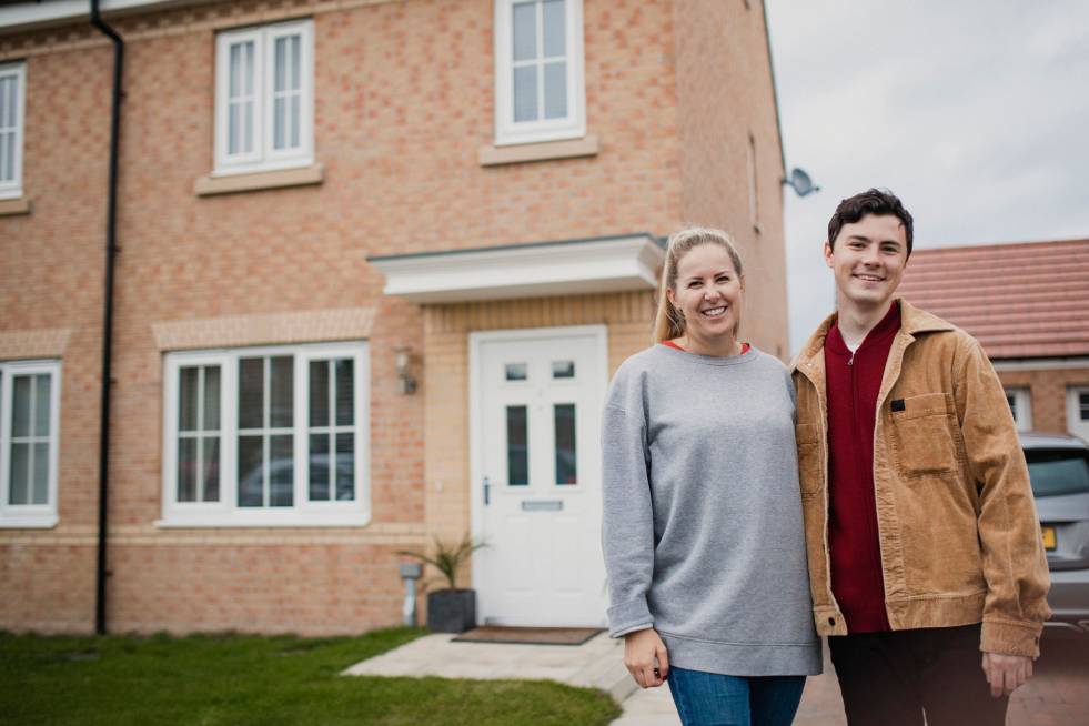 couple standing in front of the house