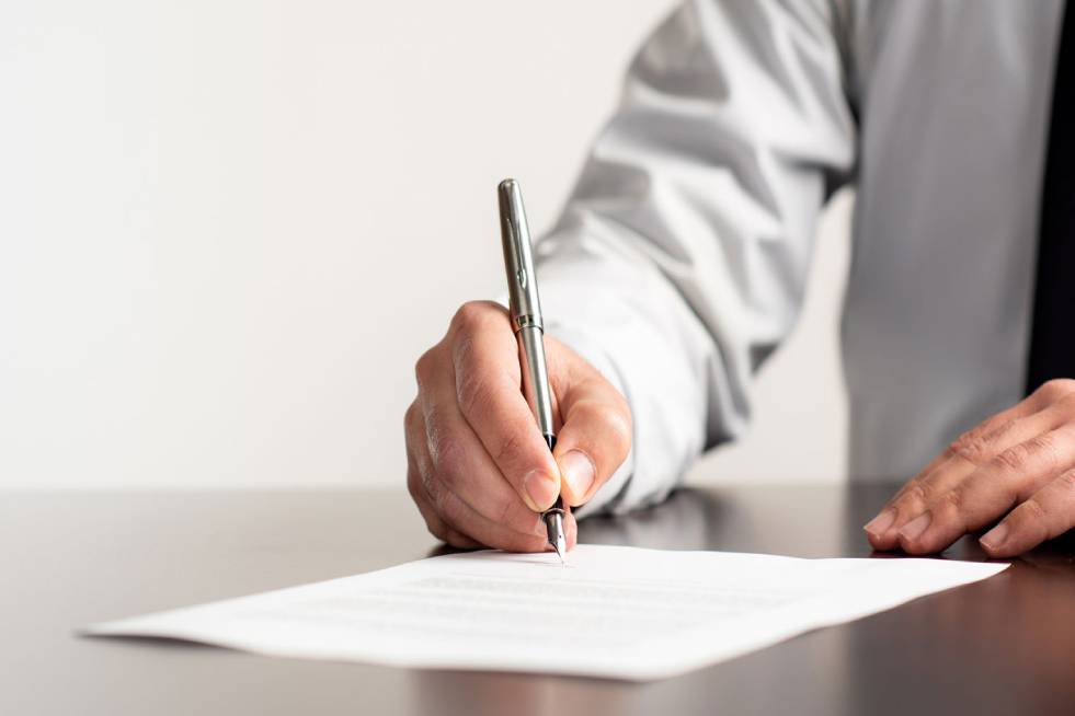 man signing property papers